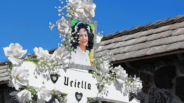 Unverkennbar: Ein Porträt der 2019 verstorbenen Uriella ziert das weiße Holzkreuz, das von weißen Seidenblumen geschmückt wird. Das Grab ...