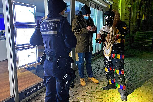 Polizeibeamte in Uniform und in Zivil kontrollieren ein Hänsele am Fastnachtssamstag 2021. Archivbild.