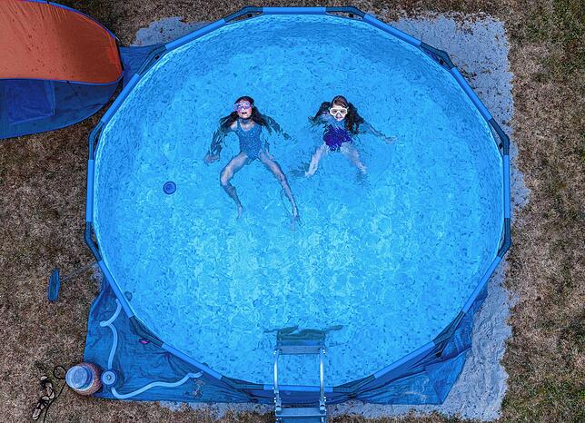 Zwei Kinder planschen in einem Pool im Garten. Auch in den kommenden Tagen soll es heißt werden.