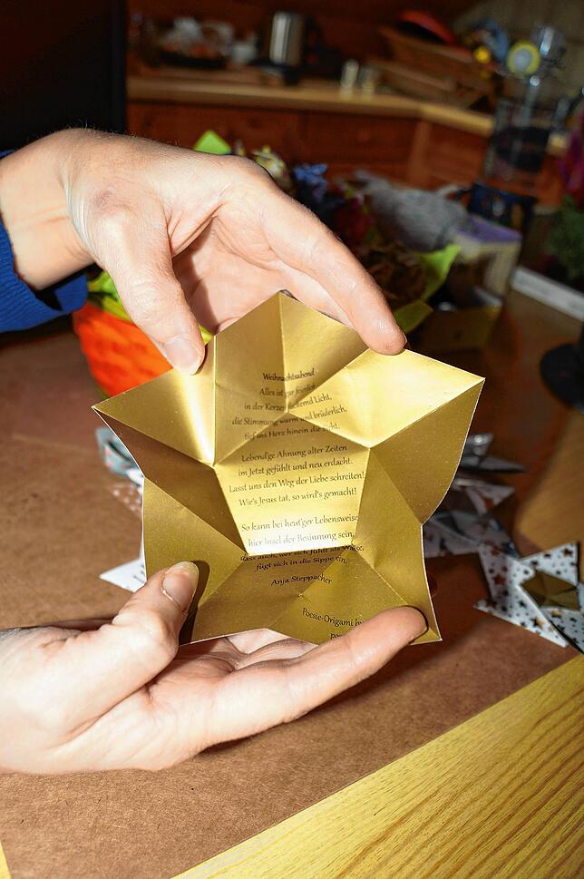 Zuerst faltet Anja Steppacher Papierblüten nach Origamie-Prinzip und bedruckt sie dann mit selbst geschriebenen Versen.