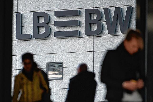 Drei Menschen gehen an der Zentrale der LBBW in Stuttgart vorbei.