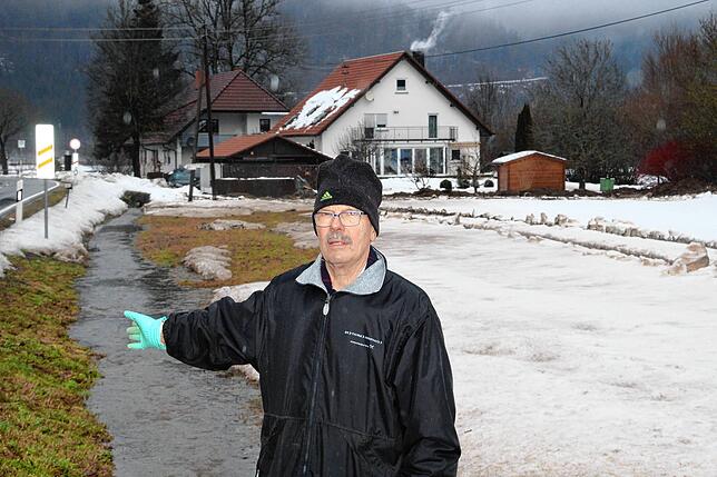 Stefan Frank zeigt, das Wasser im Straßengraben neben der Riedöschinger Ortsausfahrt, die an seinem Haus (hinten) vorbeiführt. Am ...
