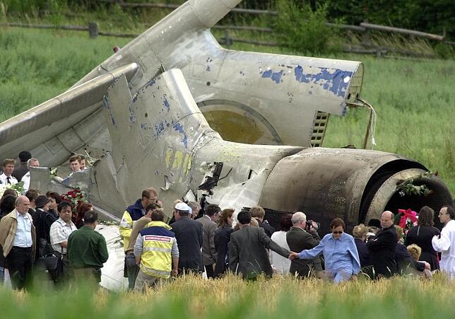 Dieses Bild ging 2002 um die Welt: Angehörige der russischen Absturzopfer trauern mit Blumen und Kränzen am zerstörten Heck der Tupolew ...