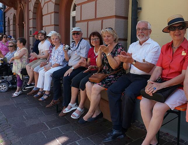 Mit guter Laune: Viele Zaungäste verfolgen den Umzug und haben ihre Freude an den bunten Trachtenträgern.
