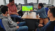 Das Team von Subsequent bei der Analyse eines Fußballspiels, bei dem freie Räume auf dem Bildschirm blau angezeigt werden. Hinten: ...