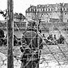 Ein Wachmann des Stalag in Villingen. Im Hintergrund sind Gefangene zu sehen.