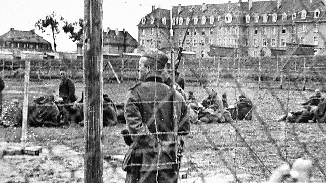 Ein Wachmann des Stalag in Villingen. Im Hintergrund sind Gefangene zu sehen.