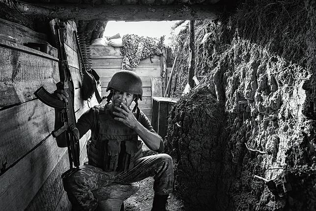Ein Frontkämpfer posiert mit seiner Kalaschnikow vor der Kamera. Andere wollen nicht fotografiert werden. Oft haben sie Verwandte auf ...