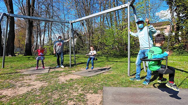 Thomas Konopka und Philip Ditting im Frühling mit ihrem Nachwuchs auf dem Spielplatz beim Lorettowald. Die Beine der Kinder reichen ...