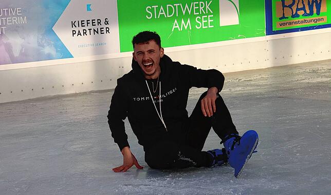 Der britische Eiskunstläufer Ian Smith lacht nach einem Sturz auf der holperigen Eisbahn, auf der er die falschen Schuhe trägt.