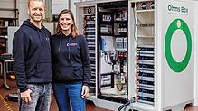 Christiane und Mark Kragh, Gründer von Off-Grid Europe, vor einem ihrer Batteriespeicher.
