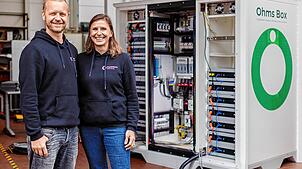 Christiane und Mark Kragh, Gründer von Off-Grid Europe, vor einem ihrer Batteriespeicher.