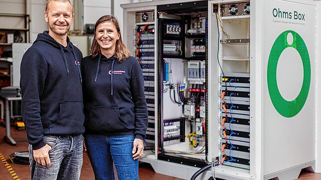 Christiane und Mark Kragh, Gründer von Off-Grid Europe, vor einem ihrer Batteriespeicher.