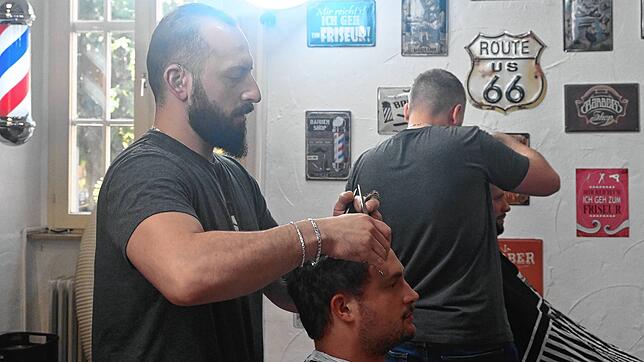 In seinem Babershop in der Münsterpassage kümmert sich Saad Allawi um die Frisur von Kilian Muchenberger. Im Hintergrund arbeitet sein ...