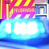 Ein Feuerwehrfahrzeug im Einsatz, davor ein Polizeiauto mit eingeschaltetem Blaulicht (Symbolbild). Ein Schlauchboot mit einem ...