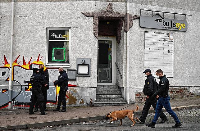 Polizisten stehen vor einer Gaststätte in Eisenach, die durchsucht wurde.