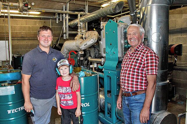 Markus Moßbrugger (links) mit seinem Sohn Max und Reinhold Moßbrugger stellen 2022 in Bruggen ihre Biogasanlage mit Wärmenetz vor.