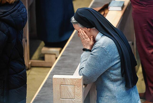 Nach dem Tod von Papst Franziskus trauert eine Frau während eines Gottesdienstes in der Domkirche St. Eberhard in Stuttgart.