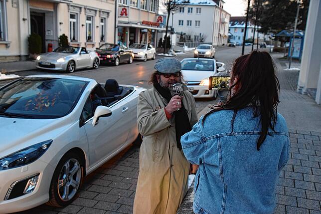 Noreen Vollmer ist hinter der Kamera, ihr Vater Rainer davor. Im Hintergrund sind die abfahrbereiten Cabrios verteilt.