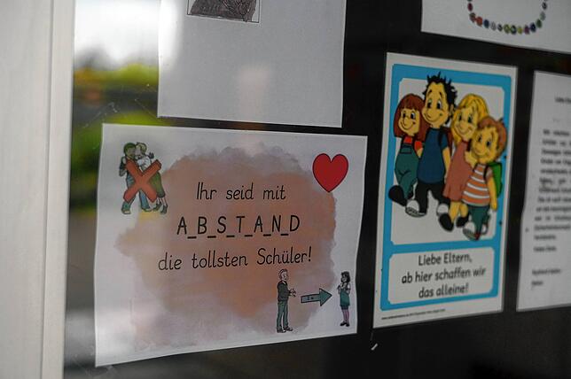 An den Türen der Schule hängen liebevoll gestaltete Zettel, die an die Abstandsregeln zu Coronazeiten erinnern.
