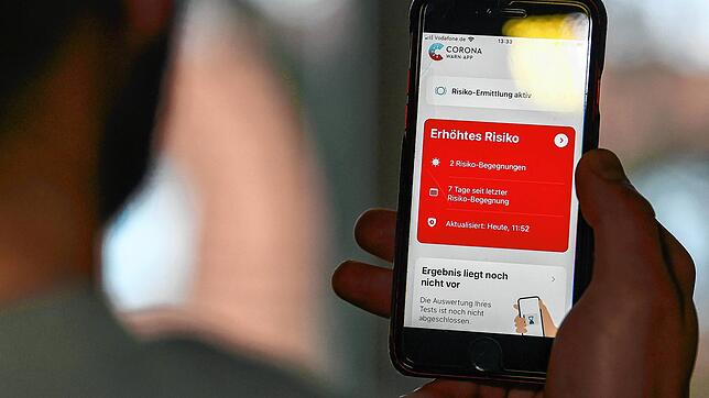 Auf einem Handy zeigt die Corona Warn-App ein erhöhtes Risiko an, welches darauf hinweist Kontakt mit einer infizierten Person gehabt zu ...
