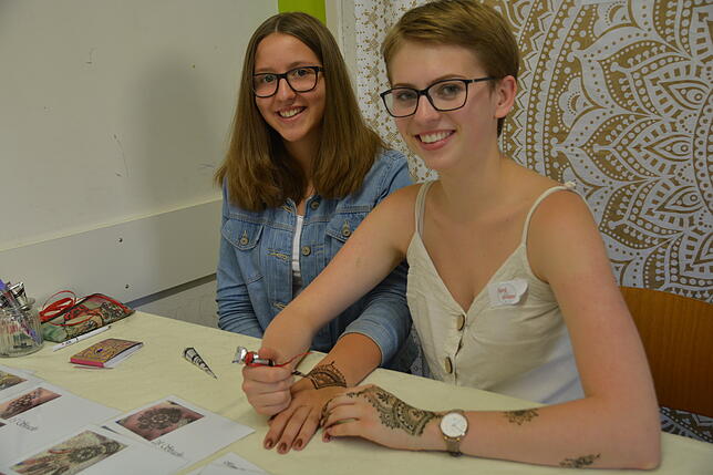 Angela Stanecker lässt sich ein Henna-Tattoo von Franka Lenski auf die Hand malen.