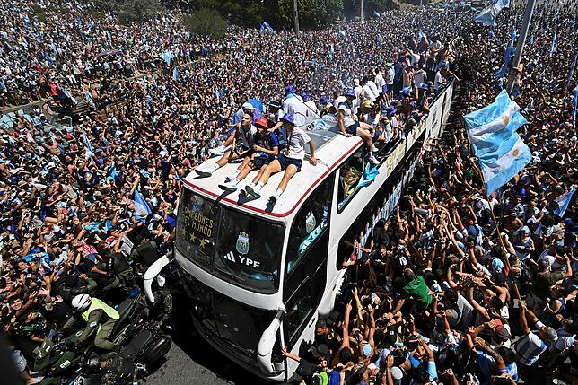 Die argentinische Fußballmannschaft fährt auf einem offenen Bus durch die Menschenmassen in Buenos Aires