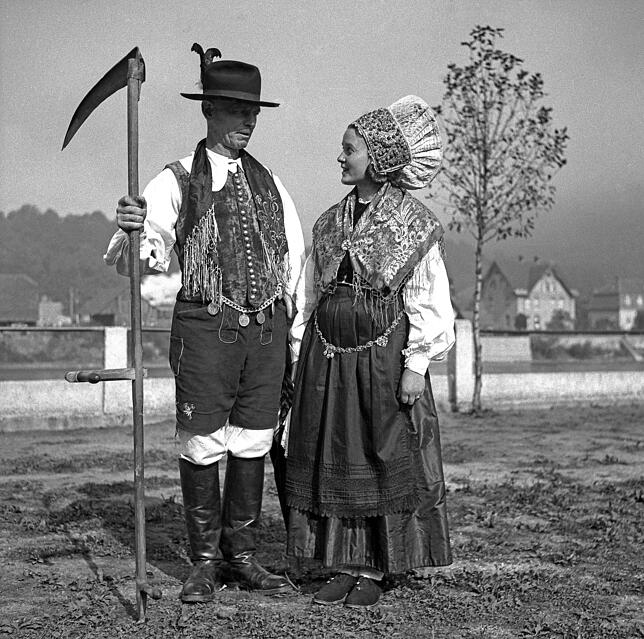 Ein Landwirt und seine Frau in Schwarzwälder Tracht. Die Sense musste lange geschwungen werden, denn die Hanglagen verhinderten lange ...