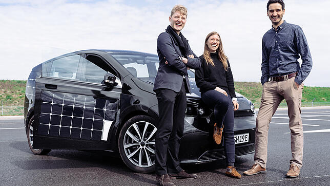 Solarzellen auch auf den Türen: Die Sono-Motors-Gründer Jona Christians (links) und Laurin Hahn mit einer Mitarbeiterin vor ihrem Modell ...