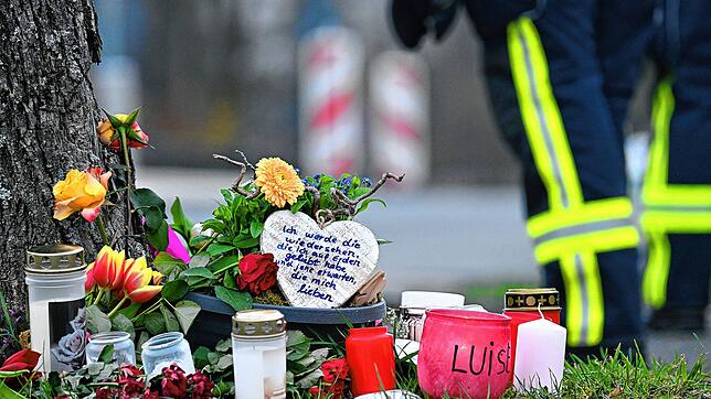 Kerzen und Blumen liegen an einem Baum an der Gesamtschule Freudenberg. Mit einer Trauerfeier nahmen Ende März Angehörige der getöteten ...