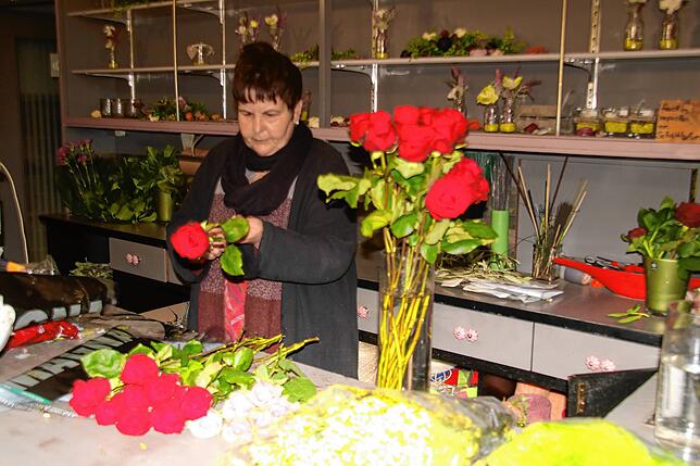 Brunhilde Weiler bindet im Laden einen Rosenstrauß.