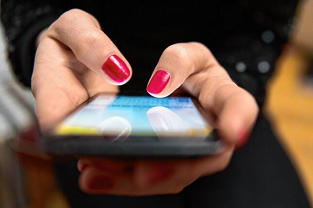 Unser Bild zum Thema sexuelle Übergriffe im Internet zeigt eine Frau, die auf einem Smartphone tippt.