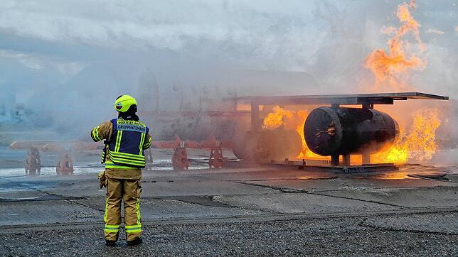 Das Triebwerk eines Flugzeugs steht am Häfler Flughafen in Flammen. Die Feuerwehr muss löschen.
