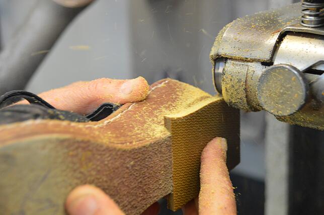 Das ist noch echtes Schuhmacher-Handwerk. Tuncay Sati schleift eine frisch geklebte Sohle ab und macht sie passend, bis der Schuh wieder ...