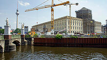 Kräne stehen auf der Baustelle des Humboldt Forums im neuen Berliner Stadtschloss. Im Hintergrund links ist der Berliner Fernsehturm zu ...