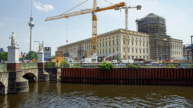 Kräne stehen auf der Baustelle des Humboldt Forums im neuen Berliner Stadtschloss. Im Hintergrund links ist der Berliner Fernsehturm zu ...