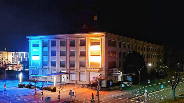Das Rathaus von Singen bei Nacht angestrahlt in den Farben der ukrainischen Flagge als ein Zeichen von Solidarität.