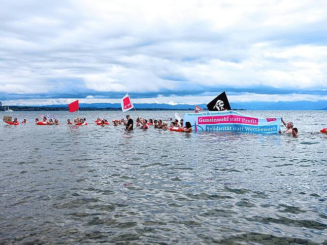 Sie gehen symbolisch baden und schicken einen Notruf vom See: Verdi-Beschäftigte protestieren in Friedrichshafen.