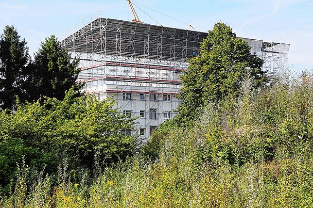 Was ist das denn für ein seltsames Gerüst? Anwohner und Passanten rätseln. Die Lösung: Hier wird ein Geschoss in Holzbauweise aufgestockt.