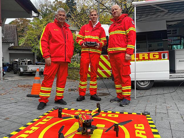 Willi Schirmeister (links), Jörg Brand (rechts) und eine der Drohnen der DLRG Sipplingen, die von Brands Sohn Valentino (Mitte), ...