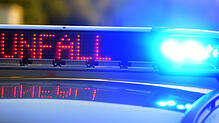 Auf einem Polizeiauto leuchtet der Warnhinweis auf eine Unfallstelle.