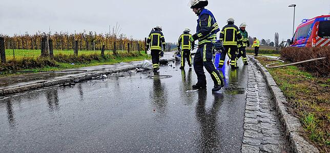 Die Einsatzkräfte der Feuerwehr entfernen die Trümmerteile von der Fahrbahn.