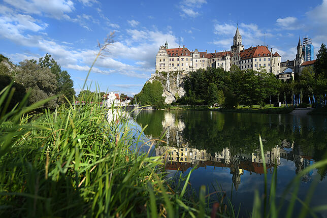 Das Hohenzollern-Schloss spiegelt sich in der Donau.