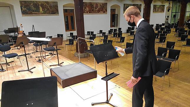 Jeder Notenständer wird desinfiziert: Orchesterwart Robert Strom bei der Arbeit.