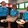 Sie bereiten regionale Produkte für die Besucher in der Mehrzweckhalle zu: Sigrid Thiele (Mitte) mit David Tebbe (li.) und Karin Krüger.