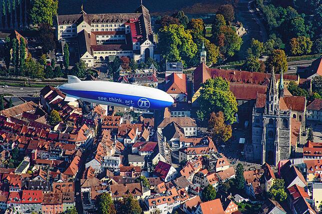 Ein Zeppelin über dem Konstanzer Münster. Im Hintergrund ist die Dominikanerinsel zu sehen, wo Graf Zeppelin im einstigen Kloster zur ...
