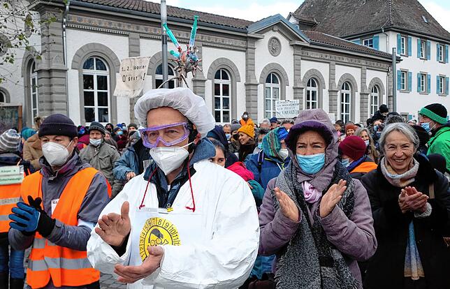 Mit Spritzen und Coronaviren gegen die Imfpflicht: Vermummte und weniger vermummte Demonstranten waren in Überlingen unterwegs.