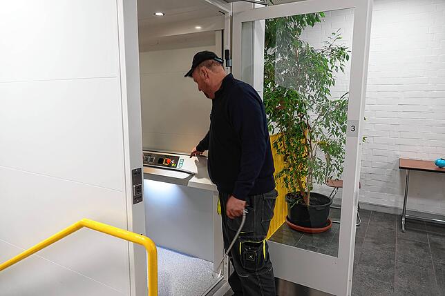 Hausmeister Bernhard Schleicher öffnet die Tür zum Personenaufzug.