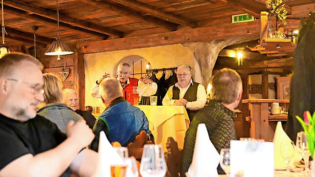 Bürgermeister Gallus Strobel (stehend, links) und Pfarrer Andreas Treuer loben in der „Lilie“ die Paten. Foto:  Hans-Jürgen Kommert
