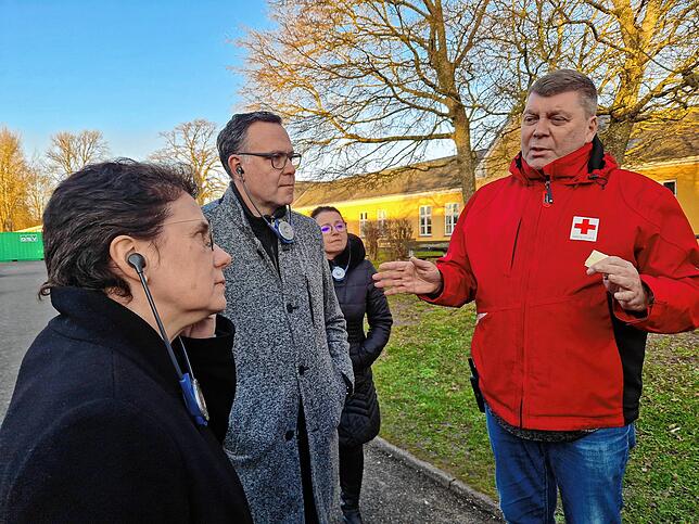 Jannich Bisp (r.) vom Dänischen Roten Kreuz erläutert den Besuchern aus Deutschland das Prozedere in Sandholm.